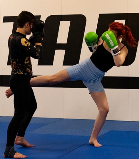 Eine Frau führt einen Kick im Boxring aus.