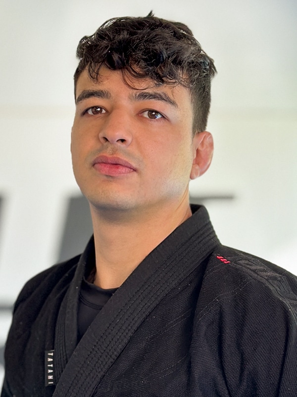 Ein junger Mann in einer schwarzen Jiu-Jitsu-Uniform.